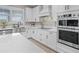 Bright kitchen featuring stainless steel appliances, elegant white cabinetry, and a stylish tile backsplash at 13139 Stanthorne Ave, Orlando, FL 32832