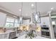 Bright kitchen with white cabinetry, stainless steel appliances, granite countertops, and stylish geometric pendant lighting at 13139 Stanthorne Ave, Orlando, FL 32832