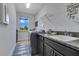 Laundry room with gray cabinets, granite counters, utility sink, washer, dryer, and a bright window at 13139 Stanthorne Ave, Orlando, FL 32832