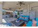 Relaxing outdoor space with a complete kitchen, tv, and comfortable seating under a ceiling fan at 13139 Stanthorne Ave, Orlando, FL 32832