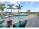 Backyard pool and patio area featuring comfortable seating, palm trees, and a lush view of the neighborhood at 13139 Stanthorne Ave, Orlando, FL 32832
