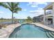 Inviting backyard oasis with a sparkling pool, lake view, palm trees, and an outdoor bar area at 13139 Stanthorne Ave, Orlando, FL 32832