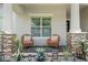 Cozy front porch with stone columns, wicker chairs, and decorative plants offers a relaxing outdoor space at 13139 Stanthorne Ave, Orlando, FL 32832