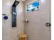 Modern shower with black shower panel, tiled walls, and a window with plants at 13139 Stanthorne Ave, Orlando, FL 32832