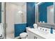 Stylish bathroom featuring textured blue wallpaper, a glass-enclosed shower, and a white vanity at 1330 W Harvard St, Orlando, FL 32804