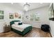 Bright bedroom with a plush emerald green bed frame, chandelier, and wood-look flooring at 1330 W Harvard St, Orlando, FL 32804