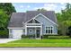 Charming home featuring a manicured lawn, a garage, and beautiful gray shingles under a cloudy blue sky at 1330 W Harvard St, Orlando, FL 32804