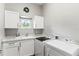Laundry room featuring modern white cabinets, plenty of counter space, and an updated washer/dryer at 1330 W Harvard St, Orlando, FL 32804