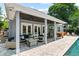 Inviting covered outdoor living space featuring a fireplace, seating, bar, and pool access at 1330 W Harvard St, Orlando, FL 32804