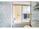 Bathroom showing tub and shower combo with blue patterned wall and sliding glass door at 1354 S Shore Dr, St Cloud, FL 34771