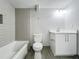 Bathroom featuring a tub with tiled wall, white toilet and vanity on wood-look floors at 1414 Beaver Pl, Orlando, FL 32806