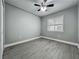 Cozy bedroom with wood-look tile flooring, a ceiling fan, and a bright window at 1414 Beaver Pl, Orlando, FL 32806