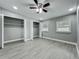 Bedroom featuring two windows, two closets, ceiling fan, and gray wood-look flooring at 1414 Beaver Pl, Orlando, FL 32806