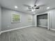 Bedroom featuring two windows, closet, ceiling fan, and gray wood-look flooring at 1414 Beaver Pl, Orlando, FL 32806