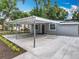 Gray single-story home featuring a covered parking area and beautiful landscaping at 1414 Beaver Pl, Orlando, FL 32806