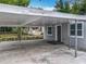 Covered parking area with a single-story home's entrance featuring a gray door and well-lit exterior at 1414 Beaver Pl, Orlando, FL 32806