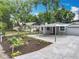 Gray single-story home featuring a covered parking area, complimented by a well-manicured front yard at 1414 Beaver Pl, Orlando, FL 32806