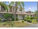 Charming townhouse exterior with tropical landscaping and a well-maintained lawn on a sunny day at 14820 Laguna Beach Cir, Orlando, FL 32824