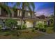 Charming townhouse exterior with tropical landscaping and a well-maintained lawn at twilight at 14820 Laguna Beach Cir, Orlando, FL 32824