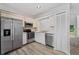 Modern kitchen with stainless steel appliances, sleek white cabinetry and wood look floors at 14820 Laguna Beach Cir, Orlando, FL 32824