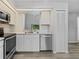 Modern kitchen with stainless steel appliances, sleek white cabinetry and wood look floors at 14820 Laguna Beach Cir, Orlando, FL 32824