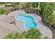 Overhead view of a sparkling blue community pool surrounded by a concrete deck and tropical palm trees at 14820 Laguna Beach Cir, Orlando, FL 32824