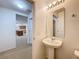 Powder room featuring a pedestal sink, mirror, and modern lighting at 1513 Blue Sky Way, Clermont, FL 34714