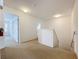 Upstairs hallway featuring carpet floors, multiple rooms, and access to the stairs at 1513 Blue Sky Way, Clermont, FL 34714
