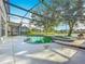 Enclosed private pool area with a lush green swimming pool and hot tub overlooking the lake at 1513 Blue Sky Way, Clermont, FL 34714