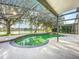 Enclosed private pool area with a lush green swimming pool overlooking the lake at 1513 Blue Sky Way, Clermont, FL 34714