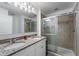 Bathroom featuring granite counters, dual sinks, framed mirror, and glass-enclosed shower at 16162 Arbor Crest Aly, Winter Garden, FL 34787