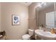 Half bathroom features tile floors, single sink vanity, mirror, and wall art at 16162 Arbor Crest Aly, Winter Garden, FL 34787