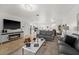 Open-concept living room with tile flooring, modern lighting, and view into the kitchen and dining area at 16162 Arbor Crest Aly, Winter Garden, FL 34787