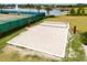 Aerial shot of a sand volleyball court near a serene lake, part of a community's recreational facilities at 16162 Arbor Crest Aly, Winter Garden, FL 34787