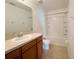 Bathroom featuring a large mirror, vanity with sink, toilet, and shower over tub with white tiles at 1625 Priory Cir, Winter Garden, FL 34787