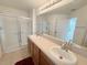 Bright bathroom features a double sink vanity and tiled shower with sliding glass doors at 1625 Priory Cir, Winter Garden, FL 34787
