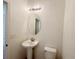 Half bathroom featuring a pedestal sink, elongated toilet and vanity mirror with overhead light at 1625 Priory Cir, Winter Garden, FL 34787