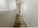 Hallway with wood-look flooring and neutral paint, connecting different areas of the upper level at 1625 Priory Cir, Winter Garden, FL 34787