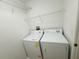 A small laundry room featuring a washer and dryer with metal shelving at 1625 Priory Cir, Winter Garden, FL 34787