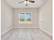 Bright bedroom features light gray walls, modern ceiling fan, and a large window with wooded views at 16253 Sw 29Th Court Rd, Ocala, FL 34473