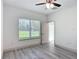 Bedroom featuring a ceiling fan, window and door, with light gray wood flooring at 16253 Sw 29Th Court Rd, Ocala, FL 34473