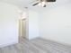 Neutral bedroom with gray wood floors, ceiling fan, and closet access at 16253 Sw 29Th Court Rd, Ocala, FL 34473
