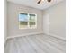 Bright bedroom features light gray walls, modern ceiling fan, and a large window with wooded views at 16253 Sw 29Th Court Rd, Ocala, FL 34473