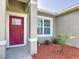 The front door is red with white trim, complemented by a small palm tree in fresh mulch at 16253 Sw 29Th Court Rd, Ocala, FL 34473