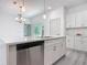 Modern kitchen island with a stainless dishwasher, sink, and cabinets with quartz countertops at 16253 Sw 29Th Court Rd, Ocala, FL 34473