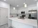 Modern kitchen boasts white cabinets, stainless appliances and an island with pendant lighting at 16253 Sw 29Th Court Rd, Ocala, FL 34473