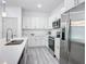 Modern kitchen featuring white cabinetry, stainless steel appliances, and quartz countertops at 16253 Sw 29Th Court Rd, Ocala, FL 34473