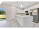 Modern white kitchen featuring a center island with pendant lighting and stainless steel appliances at 16253 Sw 29Th Court Rd, Ocala, FL 34473