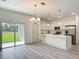 Stylish kitchen boasts white cabinets, stainless appliances, island, and sliding glass doors at 16253 Sw 29Th Court Rd, Ocala, FL 34473