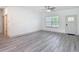 Bright living room with gray wood flooring, a ceiling fan, and a window providing natural light at 16253 Sw 29Th Court Rd, Ocala, FL 34473
